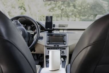 Car Air Purifier inside a car cabin between the front seats