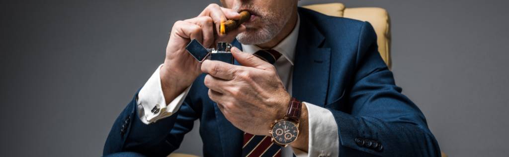 Businessman lighting a cigar