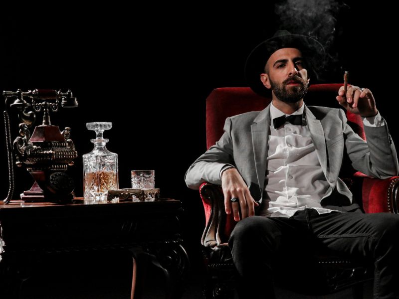 Cigar connoisseur smoking while drinking whiskey