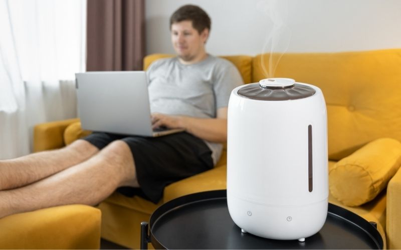 Man sitting on a sofa with a humidifier