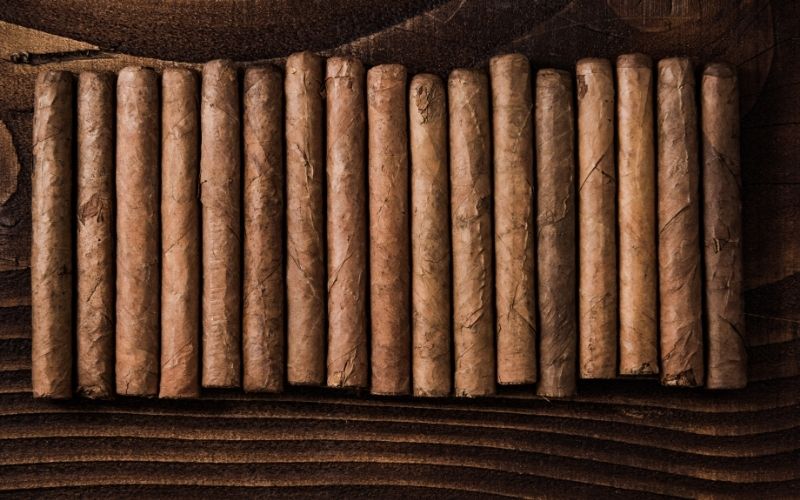 Row of cuban cigars on wooden rustic table