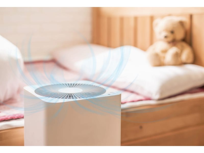 A air purifier in an aparment with a teddy bear